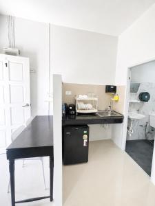 a small kitchen with a black table and a sink at Yada House Cozy Place in Nai Yang Beach