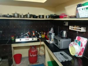 a cluttered kitchen with a stove and a microwave at Two BHK and Four BHK Fully Furnished Flats for 1 to 13 guests - Near Charminar and Salar Jung Museum in Hyderabad +51 photos