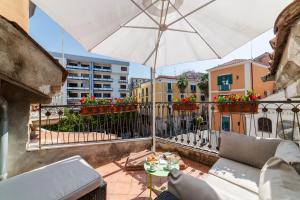 a balcony with a couch and an umbrella and a table at B&B Portanova in Salerno