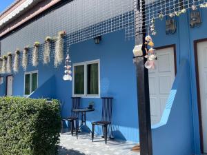 a blue house with chairs and a table in front of it at Yada House Cozy Place in Nai Yang Beach