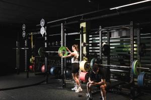 a woman is standing in a gym with a man at Sporthotel Zoll in Vipiteno