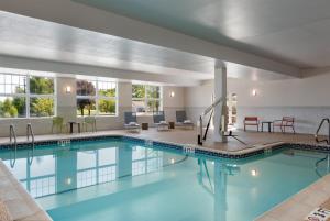 a pool in a hotel room with tables and chairs at Hampton Inn & Suites Rockland in Thomaston