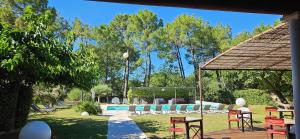 a yard with a pool and chairs and a pavilion at Les Sables d'Ocre & SPA in Roussillon