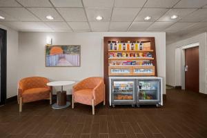 a waiting room with a refrigerator and two chairs at Hampton Inn Winfield Teays Valley in Teays Valley Estates
