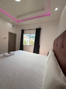 a bedroom with a large white bed with a window at โรงแรม นีโอ รีสอร์ท in Ban Thap Nang