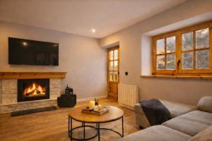 a living room with a couch and a fireplace at Luderna - Apartamento con terraza Artigues in Arties