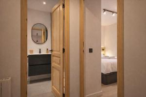 a bedroom with a bed and a bathroom with a mirror at Luderna - Apartamento con terraza Artigues in Arties