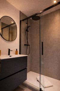 a bathroom with a shower with a sink and a mirror at Luderna - Apartamento con terraza Artigues in Arties