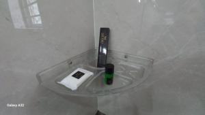 a glass table in a bathroom with a remote control at Hotel metro grand in Bangalore