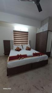 a bedroom with a large bed with red pillows at Hotel metro grand in Bangalore