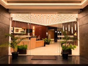 a lobby with potted plants in a building at Vio Hotel Cimanuk Bandung in Bandung