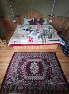 a bed in a room with a rug on the floor at Offbeat Trails in Jibhi