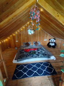 a room with a bed in a attic with a chandelier at Offbeat Trails in Jibhi