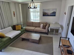 a living room with a couch and a coffee table at WEDAT APART On the beach Moda Marine Residence in Alanya