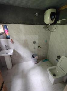 a bathroom with a sink and a toilet at Offbeat Trails in Jibhi