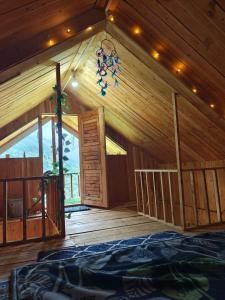 a wooden cabin with a room with a large window at Offbeat Trails in Jibhi
