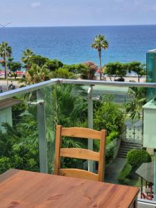 a wooden chair sitting on a balcony overlooking the ocean at WEDAT APART On the beach Moda Marine Residence in Alanya