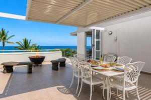 a dining room with a table and chairs and the ocean at Chakas Cove in Ballito