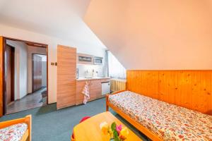 a small bedroom with a bed and a kitchen at Pension Kubát in Špindlerův Mlýn