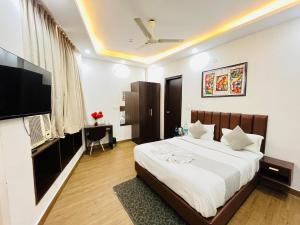 a bedroom with a bed and a flat screen tv at Hotel PP Tower - Near Ghaziabad Railway Station in Ghaziabad