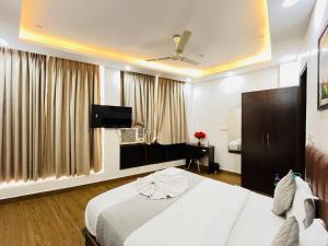 a hotel room with a bed and a flat screen tv at Hotel PP Tower - Near Ghaziabad Railway Station in Ghaziabad