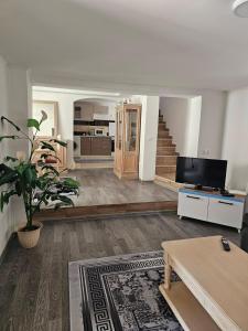 a living room with a flat screen tv and a table at Apartman Edis i Elma in Visoko