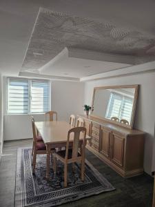 a dining room with a table and a mirror at Apartman Edis i Elma in Visoko