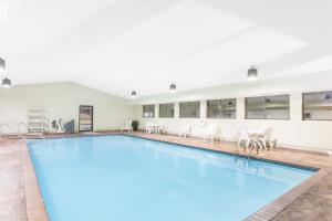 una gran piscina con sillas y un edificio en Hawthorn Suites Midwest City, en Midwest City