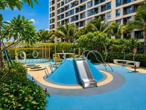 a swimming pool with a slide in front of a building at Pinnacle Moments Residence in Phnom Penh