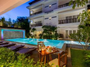 a hotel with a swimming pool in front of a building at Indra Angkor Hotel in Siem Reap