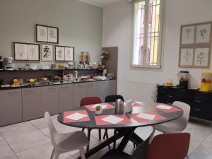 a dining room with a table and chairs and a kitchen at Residence Cavazza in Bologna