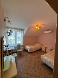 a bedroom with two beds and a table and a desk at Albatros in Chełm