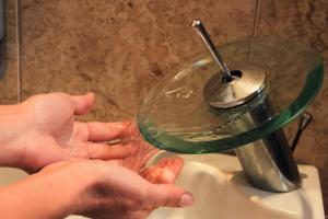 a person is washing their hands in a bathroom sink at Ulrika in Egina