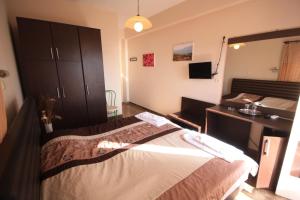 a bedroom with a large bed and a dresser at Ulrika in Egina