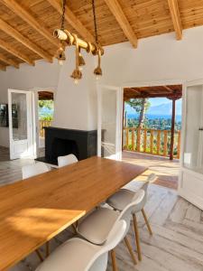 a dining room with a wooden table and chairs at Villa Keren in Oropos