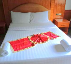 a bed with two towels and a plate on it at ปราสาทรีสอร์ท in Prasat