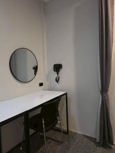 a mirror on a wall next to a desk at ปราสาทรีสอร์ท in Prasat +1 photo
