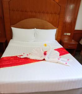 a bed with two swans made out of towels at ปราสาทรีสอร์ท in Prasat