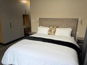 a bedroom with a large white bed with white pillows at Natures Nest with Mongi Hazyview in Hazyview +30 photos