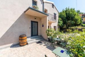 a house with a barrel in front of a door at Konoba Most Rooms in Buzet