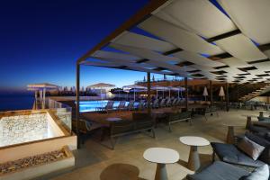 un restaurante con chimenea, mesas y sillas en Mar Azul Pur Estil Hotel & Spa en Cala Ratjada