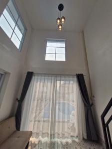 a room with a window with curtains and a chandelier at River View Villas in Vang Vieng