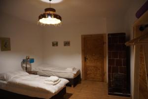 a room with two beds and a chandelier at Odpocznij w Gołdapi in Gołdap