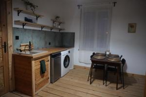a kitchen with a table and a washing machine at Odpocznij w Gołdapi in Gołdap +9 photos