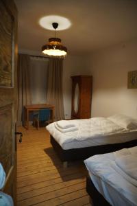 a bedroom with two beds and a table and a chandelier at Odpocznij w Gołdapi in Gołdap