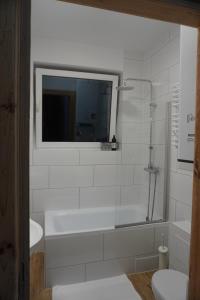 a bathroom with a tub and a toilet and a sink at Odpocznij w Gołdapi in Gołdap