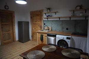 a kitchen with a refrigerator and a table with chairs at Odpocznij w Gołdapi in Gołdap