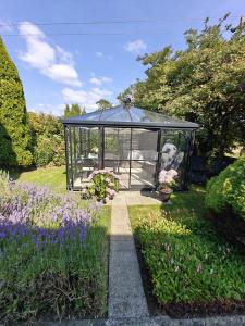 a greenhouse in the middle of a garden with flowers at Riverview House in Athlone