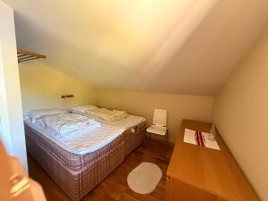 a small bedroom with a bed and a table at Bortelidseter in Åseral