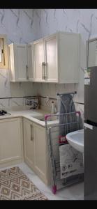 a kitchen with white cabinets and a sink at Highland Residence Al namas in Lahbey +12 photos